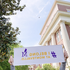 A Montevallo student holding a banner on Main Quad with the message I Belong at Montevallo.